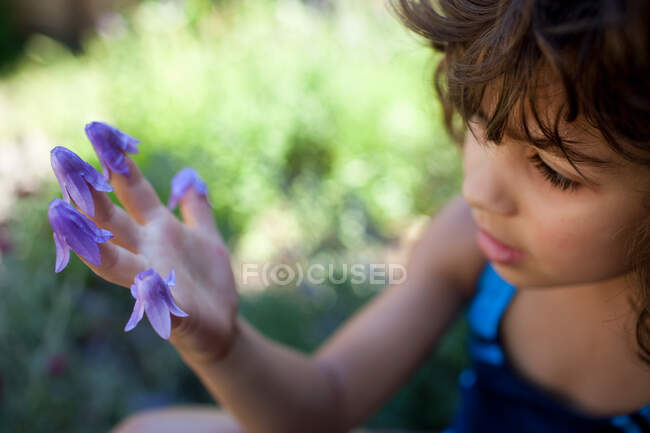 Jovem com flores nos dedos — Fotografia de Stock