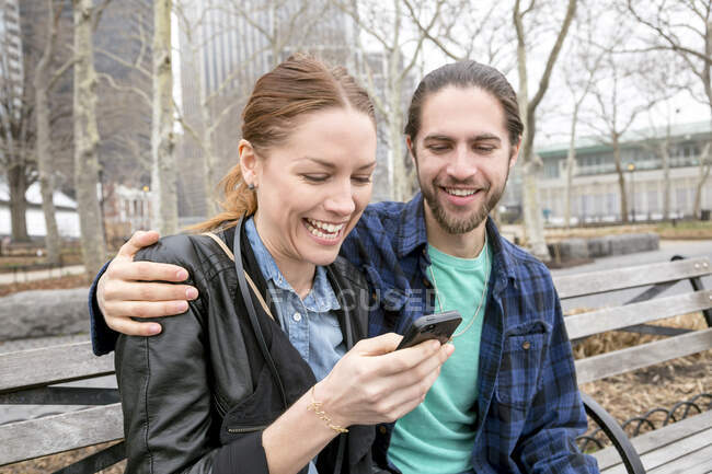 Mensagens de verificação de casal no banco do parque, Nova York, Nova York, EUA — Fotografia de Stock