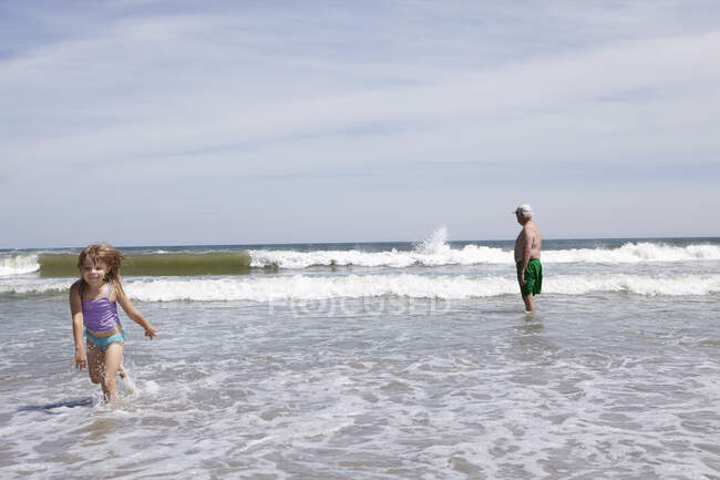 Fille jouer et courir en mer — Photo de stock