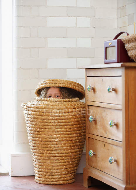 Criança escondida na cesta da roupa — Fotografia de Stock