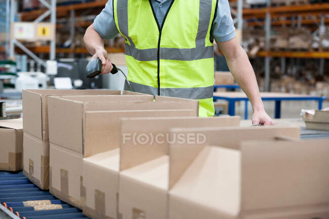 Человек, использующий считыватель штрих-кодов на складе — стоковое фото