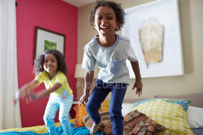 Crianças pulando na cama — Fotografia de Stock