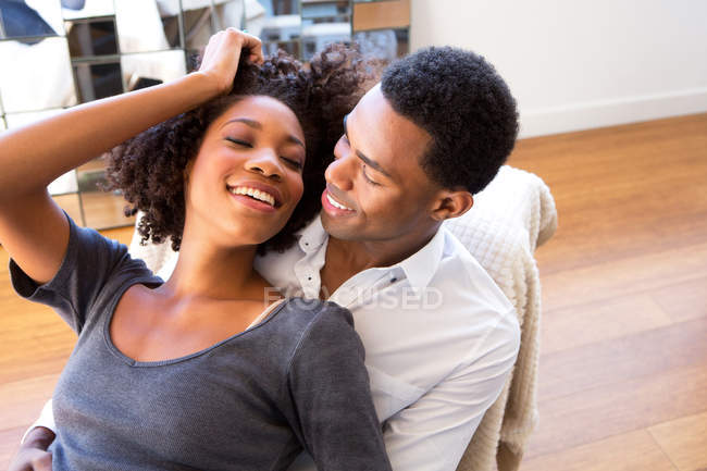 Portrait of young woman sitting on man's lap — Stock Photo