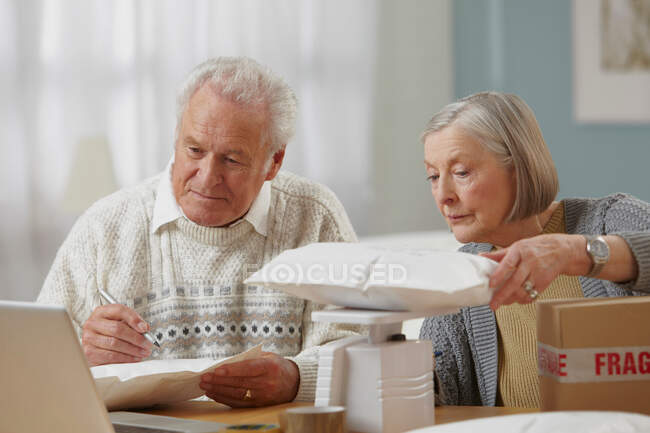 Seniorenpaar wägt Pakete ab — Stockfoto