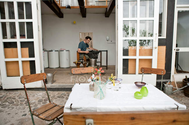 Table and chairs in courtyard, man in background — Stock Photo