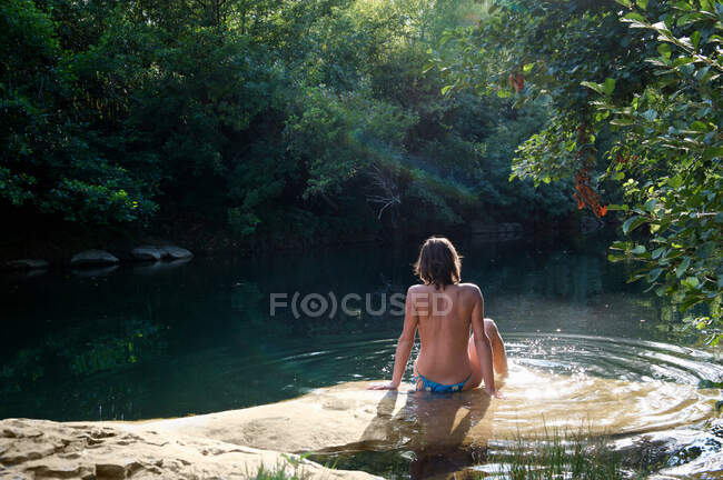 Donna seduta nel fiume — Foto stock
