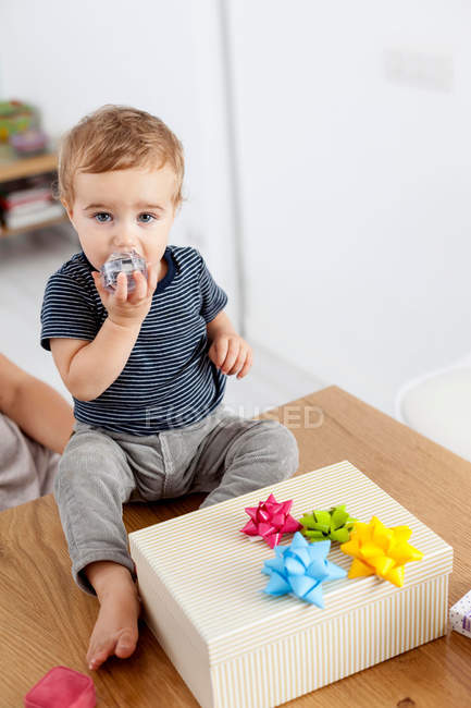 Toddler boy sitting with birthday present — Stock Photo
