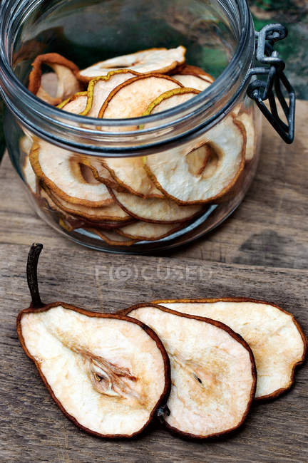 Sliced pears in jar on wooden table — Stock Photo