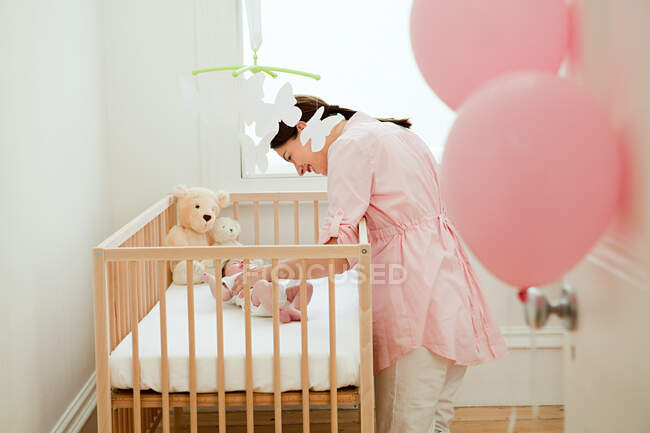 Mother with baby in crib — Stock Photo