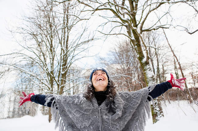 Woman in snowy woods embracing sky — Stock Photo