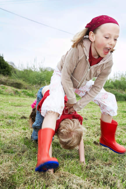 Two children playing leapfrog — Stock Photo