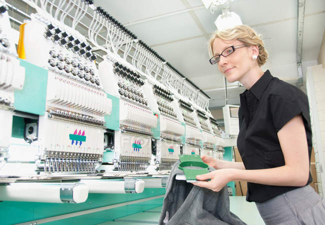 Працівник вивчає тканину на заводі — стокове фото