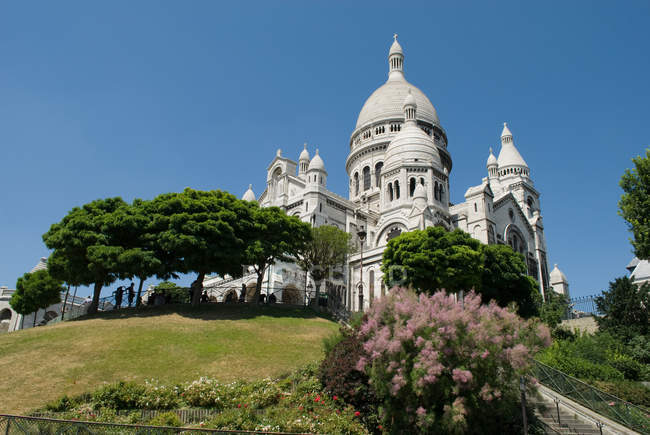 Coeur sagrado com flores e árvores em primeiro plano, Paris, França — Fotografia de Stock