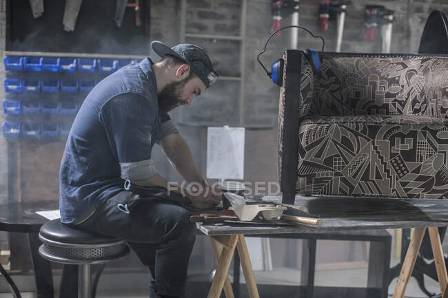 Ciudad del Cabo, Sudáfrica, hombre de mantenimiento plannin medidas de gota en el taller - foto de stock