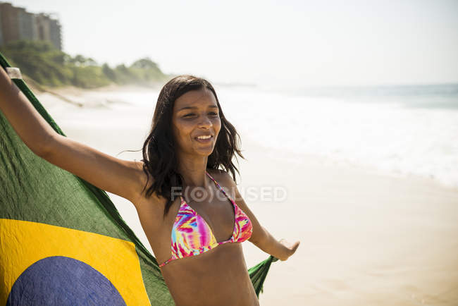 Молодая женщина с бразильским флагом, пляж Арподор, Рио-де-Жанейро, Бразилия — стоковое фото