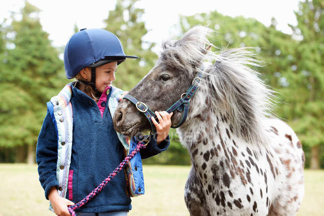 Young girl with her pony outdoors — Stock Photo