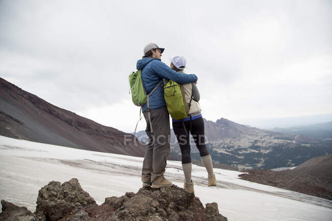 Молодая пара, стоящая на вершине вулкана South Sister, Бенд, Орегон, США — стоковое фото