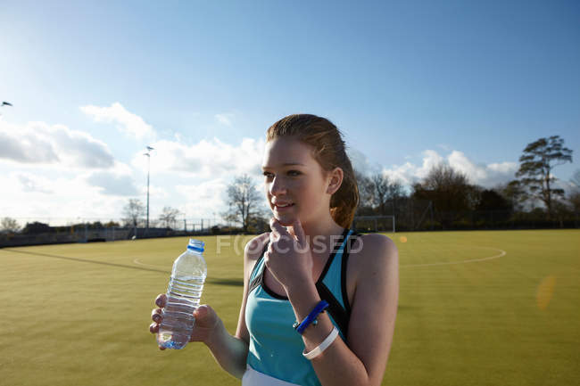Fille boire de l'eau dans le champ — Photo de stock