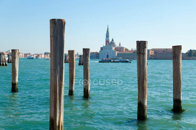Wooden posts in urban harbor — Stock Photo