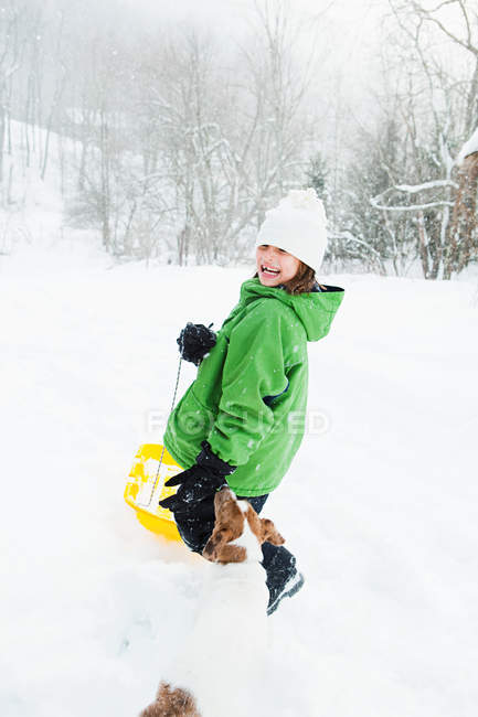 Дівчина катається на санях у снігу — стокове фото