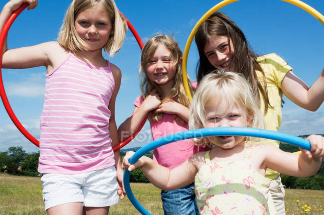 Four girls with plastic hoops, portrait — Stock Photo