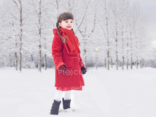 Souriante fille jouer dans la neige — Photo de stock
