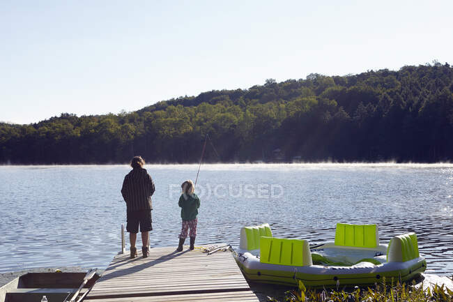 Children fishing on pier by lake, New Milford, Pennsylvania, US — Stock Photo