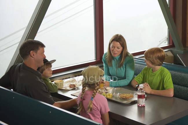 Familia tomando un descanso del senderismo, Glacier Express Restaurant, Upper Tram Terminal, Alyeska Resort, Mt. Alyeska, Girdwood, Alaska, EE.UU. - foto de stock