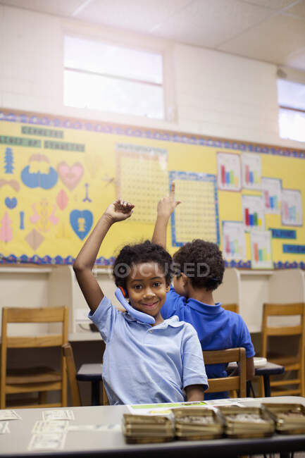 Школярі піднімають руки в класі — стокове фото