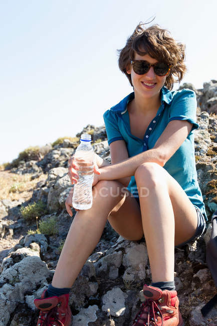 Hiker sitting on rocks, focus on foreground — Stock Photo