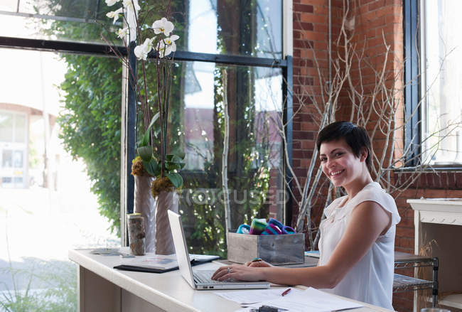 Femme d'affaires au bureau en utilisant un ordinateur portable — Photo de stock