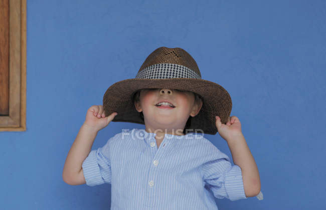 Boy playing with fathers hat — Stock Photo