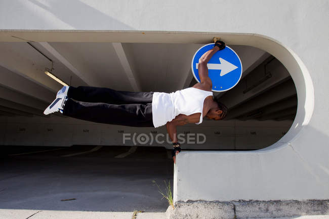 Mann balanciert auf Sims auf Stadtstraße — Stockfoto