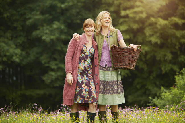 Portrait of two women in meadow with basket — Stock Photo