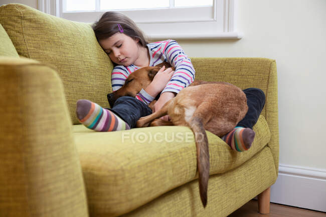 Junges Mädchen schläft mit ihrem Hund — Stockfoto