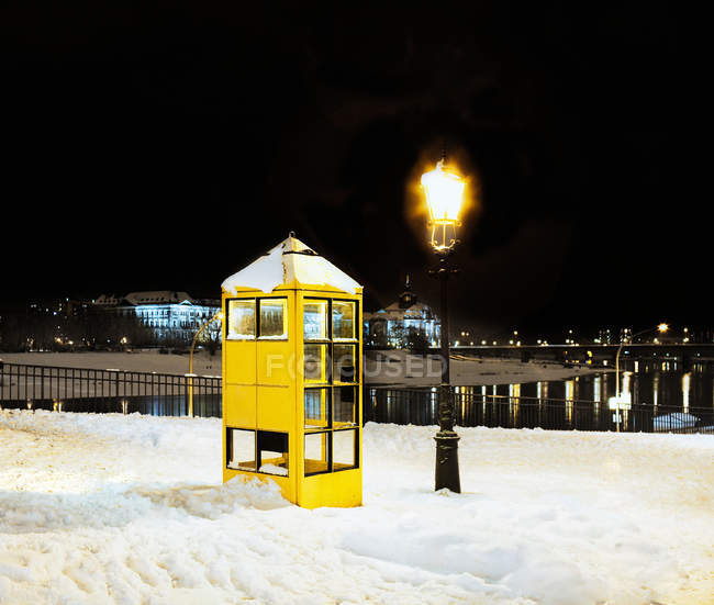 Phone booth in the snow at night — Stock Photo