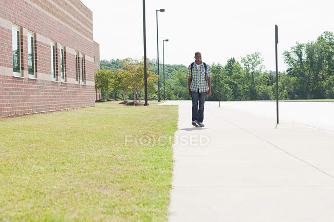 Männlicher Gymnasiast läuft an der Schule vorbei — Stockfoto