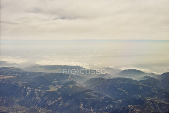Aerial view of alps mountains under cloudy sky — Stock Photo