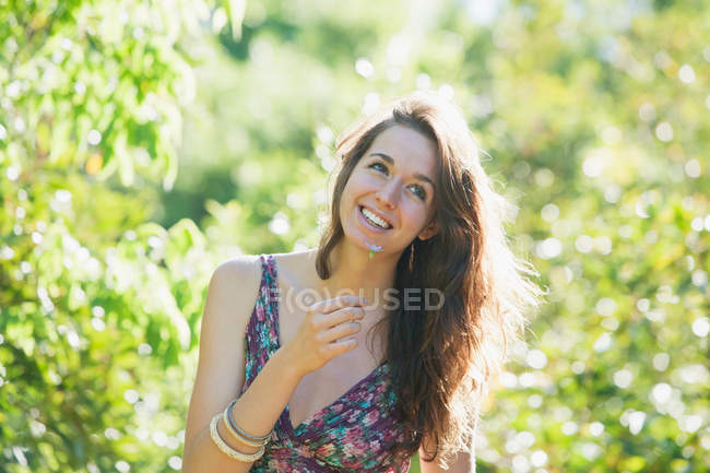 Teenage girl smelling flowers outdoors — Stock Photo