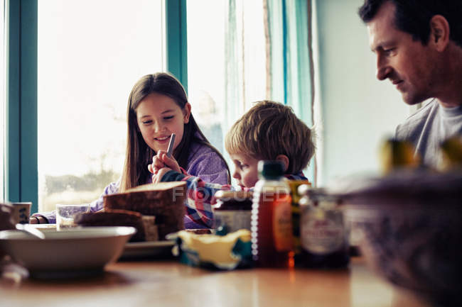 Familia comiendo juntos en la mesa - foto de stock