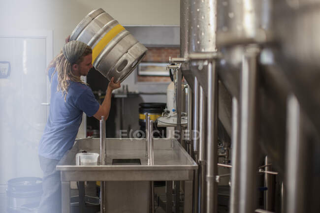 Cape Town, Sud Africa, giovane maschio nella birreria che versa birra nel lavandino — Foto stock