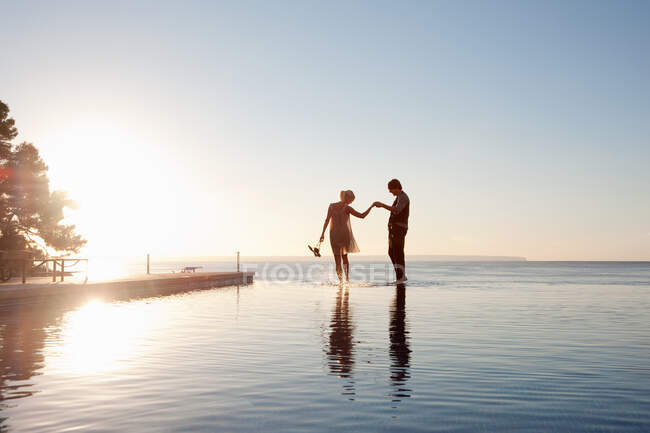 Couple in the ocean at sunset — Stock Photo