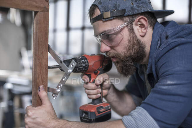 Cape Town, South Africa, close up craftsman drilling into wooden frame — Stock Photo