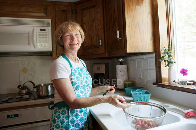 Mulher preparando morangos na cozinha — Fotografia de Stock