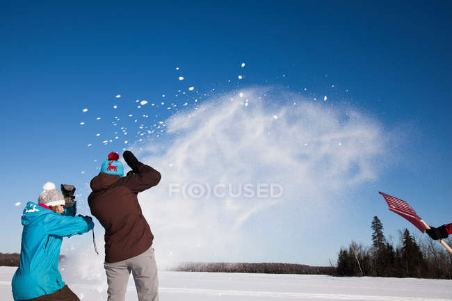 Friends playing in snow outdoors — Stock Photo