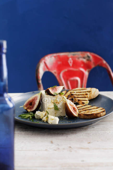 Рикотта с инжиром и хлебом на тарелке — стоковое фото