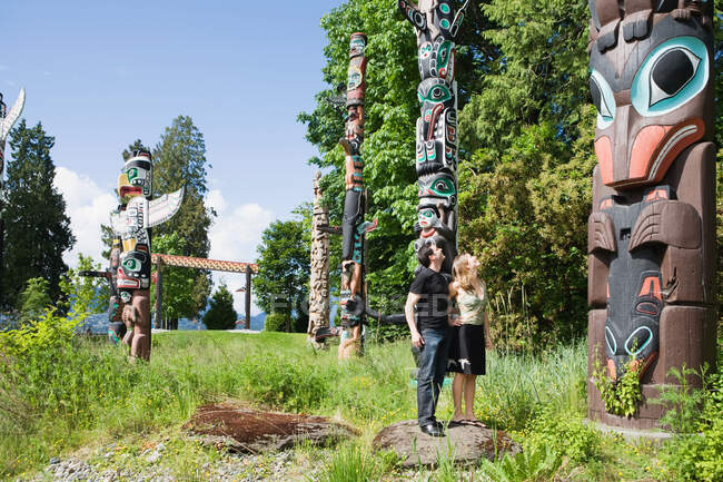 Couple looking at totem poles — Stock Photo