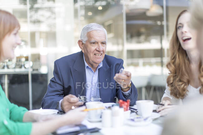 Equipo de reuniones de hombres de negocios senior en coffee break en la terraza del hotel - foto de stock