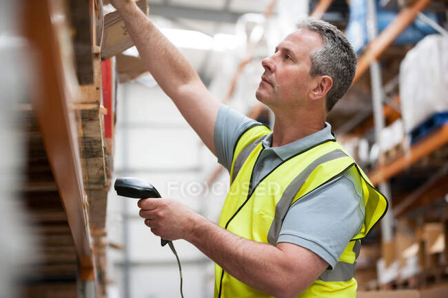 Homme utilisant lecteur de code à barres dans l'entrepôt — Photo de stock