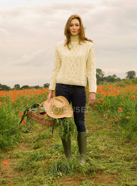 Una hembra sosteniendo una cesta de verduras - foto de stock